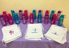 a purple table topped with lots of water bottles and napkins next to each other