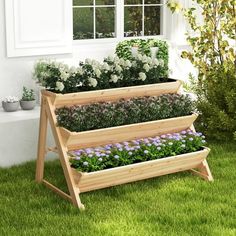 three tiered garden planter in front of a house with flowers growing out of it