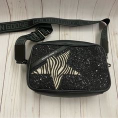 This Stunning Crossbody Bag From Golden Goose Features A Unique Zebra Star Pattern That Is Sure To Turn Heads. The Exterior Is Made Of High-Quality Leather And Adorned With Stunning Sparkly Accents. The Bag Comes With An Upgraded Cross-Body Strap That Says “Golden Goose” And Has A Zip Closure For Added Security. The Bag Is Small In Size, Measuring 9 Inches In Width, 6 Inches In Height, And 4 Inches In Depth. This Bag Is Part Of The Golden Goose Product Line, Made In Italy, And Is Perfect For Wom The Golden Goose, Glitter Bag, Golden Goose, Black Glitter, Star Patterns, High Quality Leather, Bags Handbags, Crossbody Bag, Bag Lady