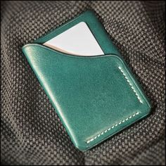 Stylish HANDMADE small English Leather wrap wallet. Dark green colour. 2 pockets. Approx. 10x7cm. This wallet is hand stitched with contrasting White Ritza thread. Will hold 2-3 cards in outer pocket and 3-4 more cards plus paper money in centre pocket. This slim stylish wallet will age well with use. Ideal gift for someone you love. FREE SHIPPING UK.