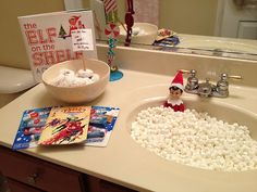 an elf is sitting in the bathroom sink with marshmallows all over it