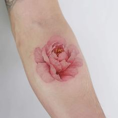 a pink flower tattoo on the left arm and right arm with an insect in it