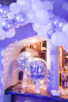 balloons and disco balls are on display in front of a mirror