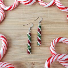 the candy cane earrings are decorated with red, green and white stripes