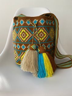 This is a handmade crochet shoulder bag made by the Wayuu tribe from Colombia. Is one thread weaven, made with ancestral wisdom and special meaning. It's said  every "mochila" chose its Owner... is this one for you? Take it to the beach, for a casual dressing shopping day , on your trips... it looks so hippie chic and everyone will talk about it 100% COTTON directly from the Wayu' community in Guajira  Colombia, with your purchase, we help the Wayuu people to its development and evolution. Appro Bohemian Bucket Crochet Bag For Festival, Bohemian Crochet Bucket Bag For Festival, Bohemian Handwoven Bucket Bag, Bohemian Handwoven Crochet Bag For Travel, Brown Bohemian Crochet Bag For Festivals, Bohemian Bucket Crochet Bag With Weaving, Bohemian Bucket Crochet Bag With Weaving Details, Bohemian Crochet Bucket Bag With Weaving, Bohemian Brown Crochet Bag With Weaving