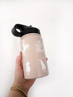 a hand holding a pink water bottle with white horse and rider decals on it