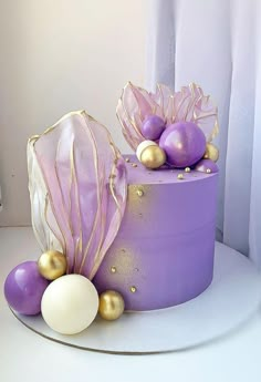 there is a purple cake with gold decorations on it