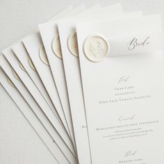 the wedding program is laid out on top of each other, with a wax seal