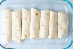 several tortillas are arranged in a glass dish