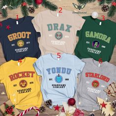 four t - shirts with the names and numbers of different sports teams are on display in front of christmas decorations