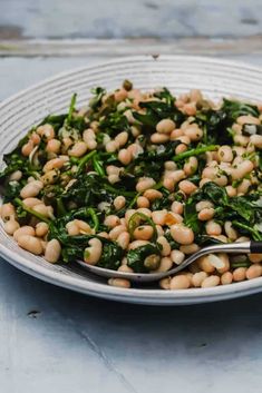 a white plate topped with beans and spinach