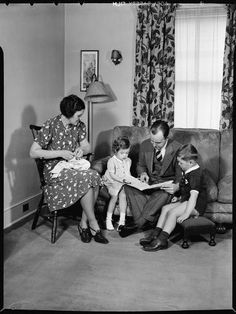 an old black and white photo of three people sitting on a couch with a child