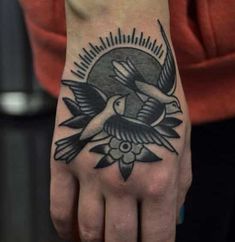 a person with a bird tattoo on their hand