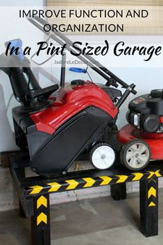 a red lawn mower sitting on top of a wooden table next to a black and yellow caution line