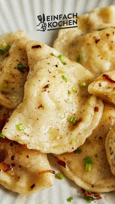 a white plate topped with dumplings covered in sauce