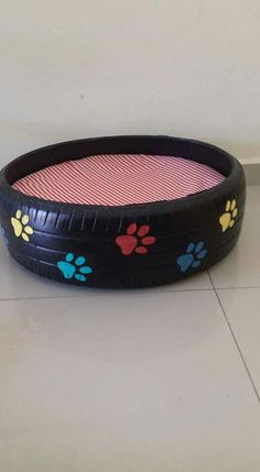 a dog bed made out of an old tire with paw prints on the rim and bottom