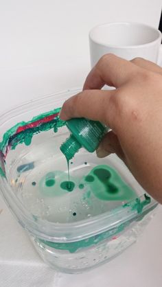 someone is painting the inside of a bowl with green paint