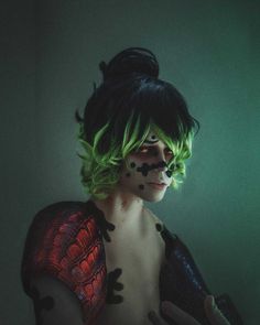 a woman with green hair and black makeup