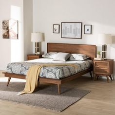 a bed room with a neatly made bed and two nightstands on either side of the bed