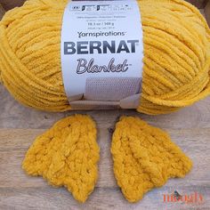 a ball of yarn with two yellow mittens