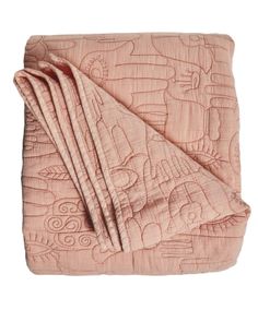 the pink quilted blanket is folded up