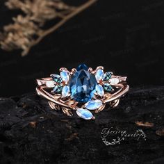 a ring with blue stones and leaves on it