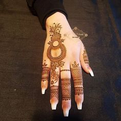 a woman's hand with henna tattoos on it