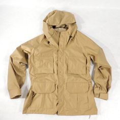 "Vintage Hunting Parka Two-way zipper with storm flap closure, 4 flap pockets, 2 elastic shotgun shells holders, velcro-adjustable cuffs, hood Mens label: L (FITS MEN'S L TO XL) Please check the measurements Measurements approx.: pit to pit across front 26\", length from collar seam to the end of sleeve 33\", jackets length approx 32\" Condition: great condition Mfg.: Gamehide C 1970's-80's" Tactical Khaki Outdoor Outerwear, Khaki Techwear Windbreaker For Hunting, Tactical Khaki Windbreaker With Pockets, Functional Khaki Parka For Outdoor Work, Khaki Windproof Windbreaker For Hunting, Tactical Outdoor Outerwear With Pockets, Hooded Techwear Windbreaker For Hunting, Functional Windproof Windbreaker For Hunting, Functional Hunting Outerwear With Pockets