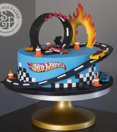 a blue cake with cars and flames on top