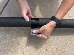 a man holding onto a black pole with his hand on the handle and wristband