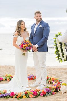 a man and woman standing next to each other on a beach