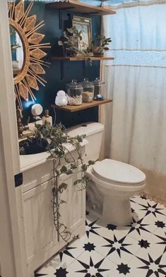 a white toilet sitting in a bathroom next to a shower curtain and tiled flooring