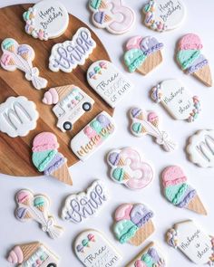 decorated cookies are arranged on a wooden platter with the words happy birthday and ice cream