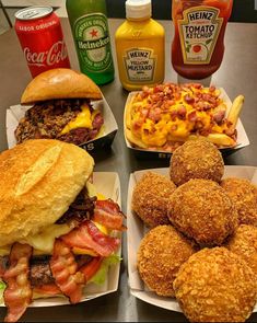 several different types of food sitting on plates next to sodas and condiments