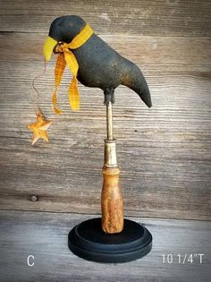 an old fashioned bird with a yellow scarf on it's head is perched on a wooden stand