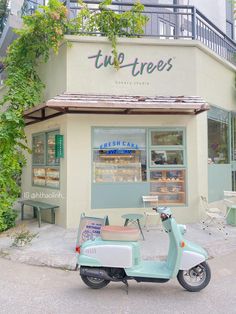 a scooter parked in front of a store with trees growing on the side