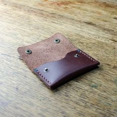 a leather wallet sitting on top of a wooden table