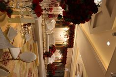 a room filled with lots of tables covered in flowers and white chairs sitting next to each other