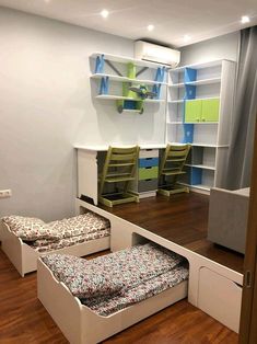 a room with two chairs and a bed on the floor in front of a book shelf