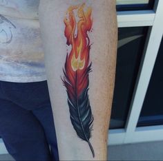 a person with a tattoo on their arm has a red and orange feather in flames