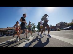 a group of people running down a street