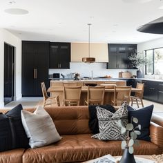 a living room filled with furniture next to a kitchen and dining room table in front of a window