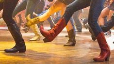 a group of people standing on top of a wooden floor with their feet in the air