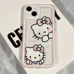 an iphone case with two hello kitty images on the front and back cover, sitting on top of a white box