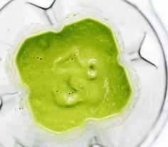 a blender filled with green liquid on top of a table