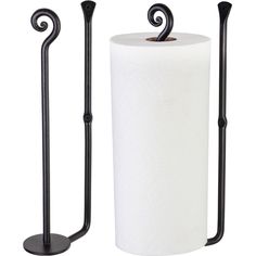 two black metal toilet paper holders next to one white roll and the other is empty