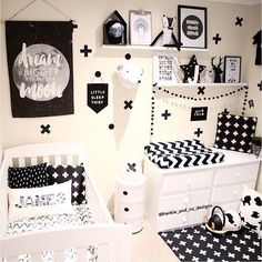 a black and white nursery with lots of pictures on the wall