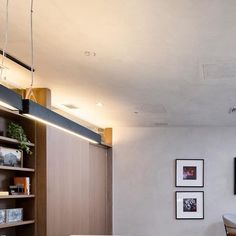 a living room filled with furniture and pictures on the wall next to a book shelf