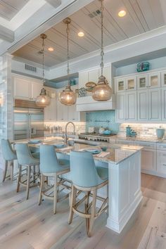 a large kitchen with white cabinets and blue bar stools in front of an island