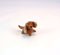 a small brown dog figurine sitting on top of a white surface